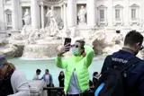 Woman in front of fountain taking selfie