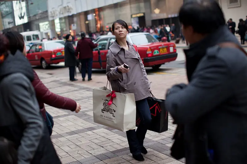 Gatuscen från stad i Asien med kvinna med shoppingkassar.