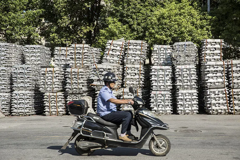 Mann på motorsykkel foran stabler med aluminium