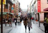 A shopping street in Japan with pedestrians pictured