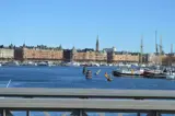  Utsikt över en vattenkanal i Stockholm med båtar förtöjda längs kajen.