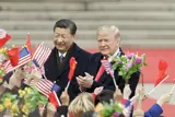 Præsident Jinping og Donald Trump i mørke jakker med viftende flag.